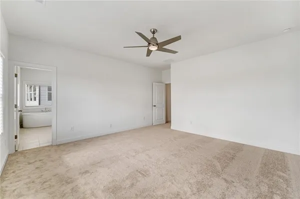 an empty room with a ceiling fan and window