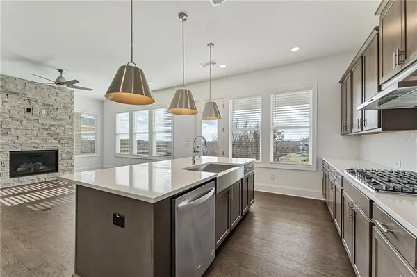 a kitchen with granite countertop a sink stove and cabinets