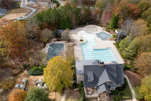 an aerial view of a house with a yard and large tree