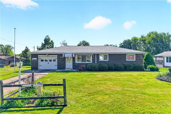 a view of a house with a big yard and potted plants