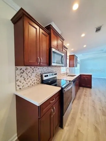 a kitchen with stainless steel appliances granite countertop a sink stove and cabinets