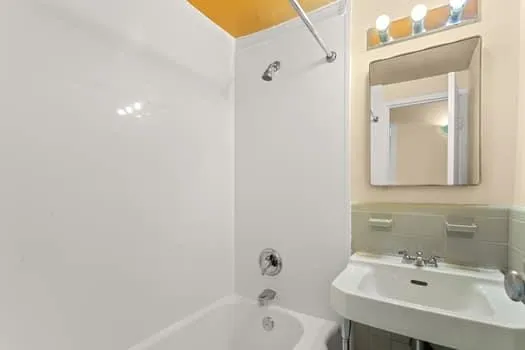 a bathroom with a sink a mirror and a bathtub