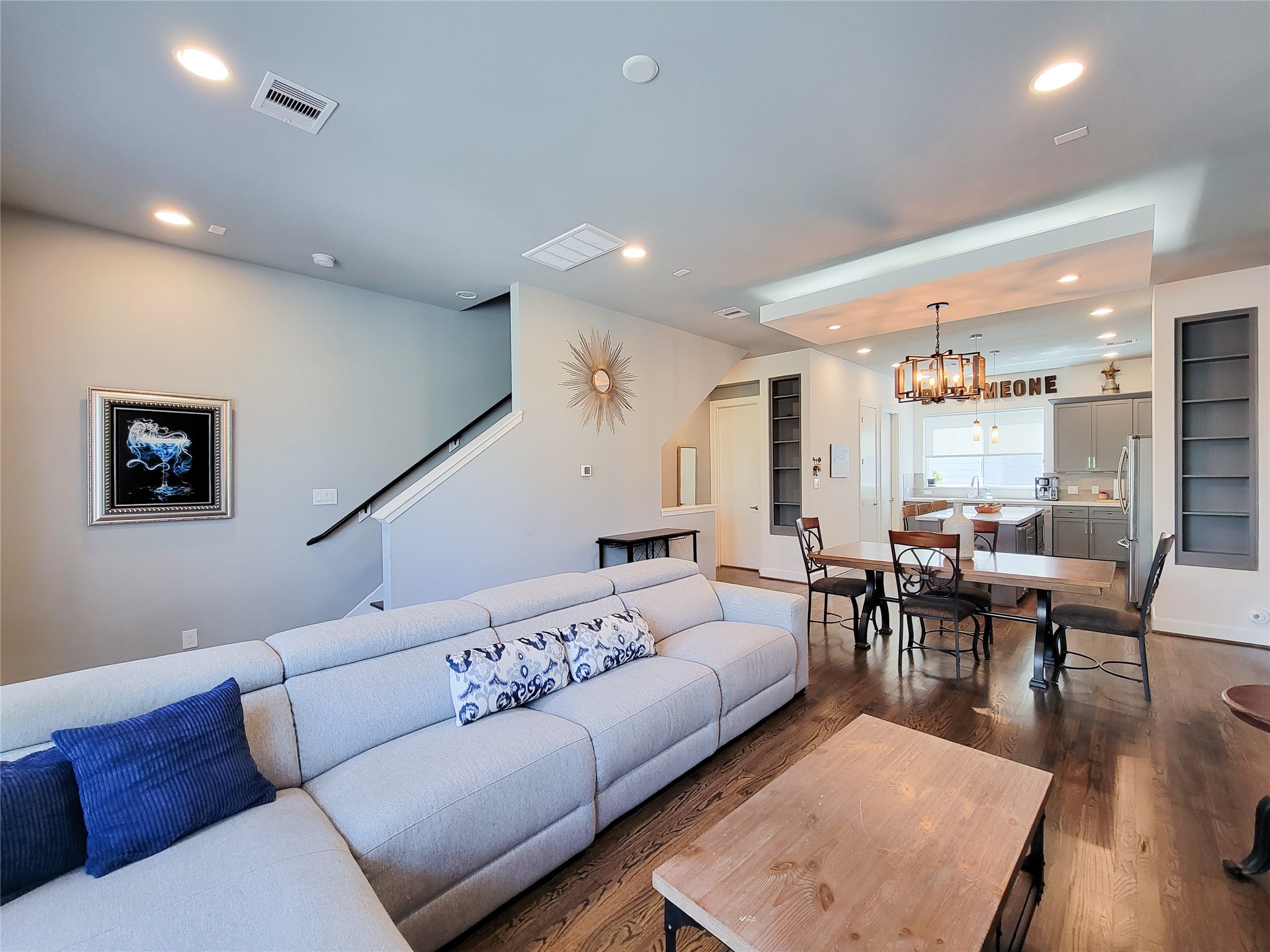 1705 Eado Point Lane Houston, TX 77003 - Photo 16 of 50 An open-concept living and dining area with modern decor. The room is well-lit with recessed lighting and has hardwood floors throughout, creating a warm and inviting atmosphere.