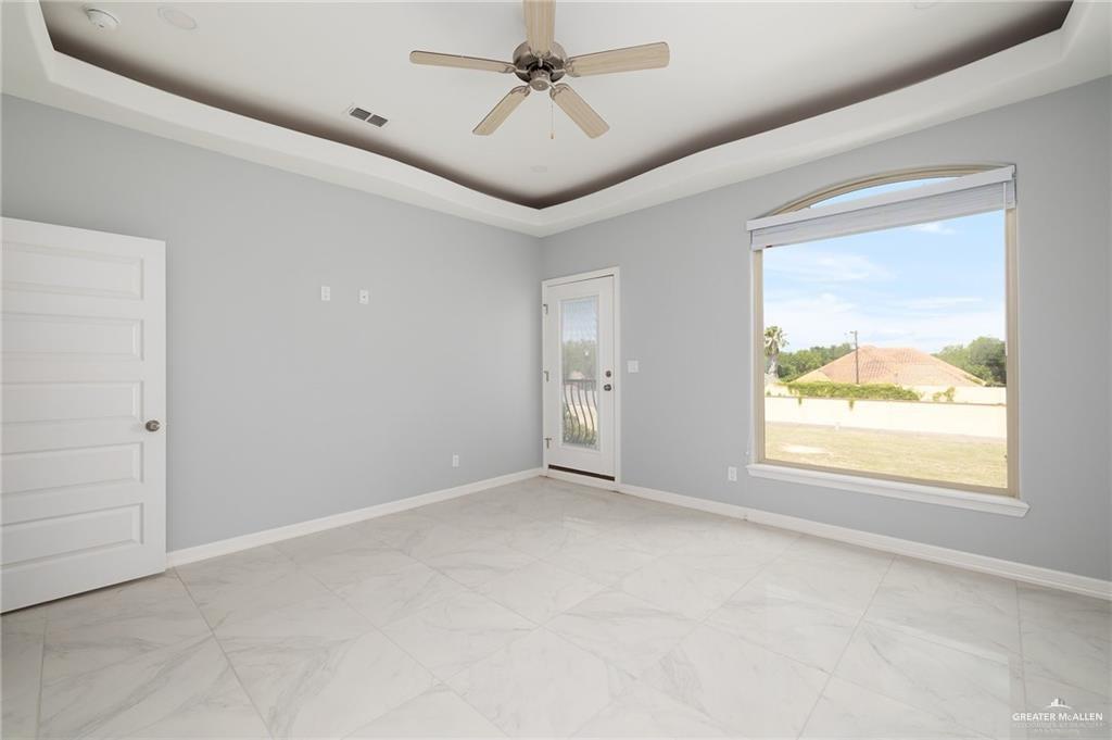 5307 North Crown Point Pharr, TX 78577 - Photo 5 of 11 Empty room featuring a tray ceiling and ceiling fan