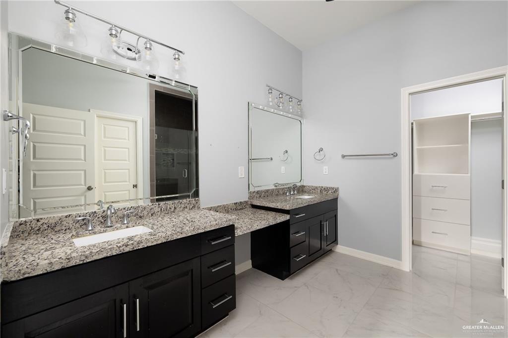 5307 North Crown Point Pharr, TX 78577 - Photo 7 of 11 Bathroom featuring two vanities, light marble finish floors, and a walk in closet