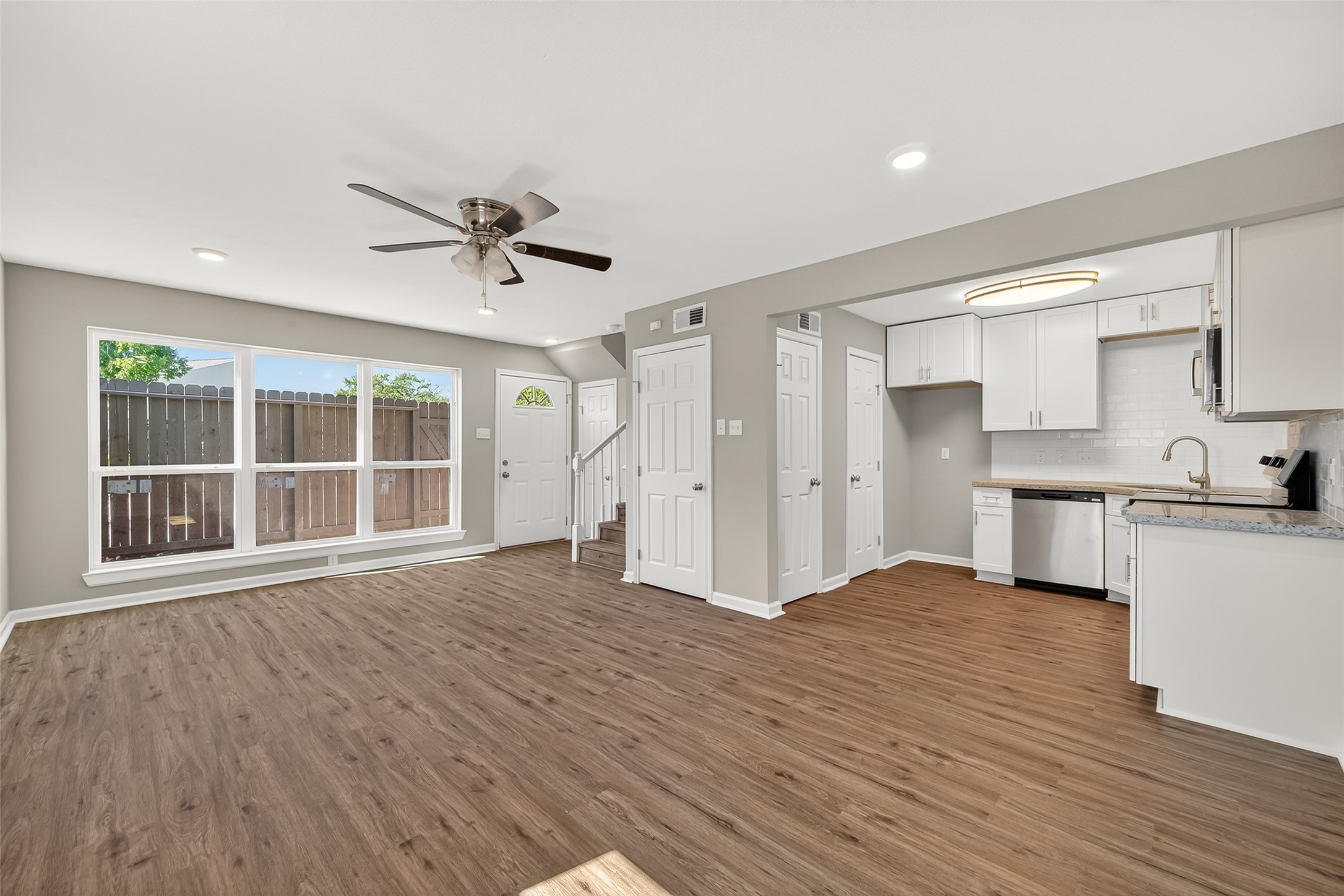 7047 Bissonnet Street, Unit 54 Houston, TX 77074 - Photo 12 of 30 a view of an empty room with a kitchen and wooden floor