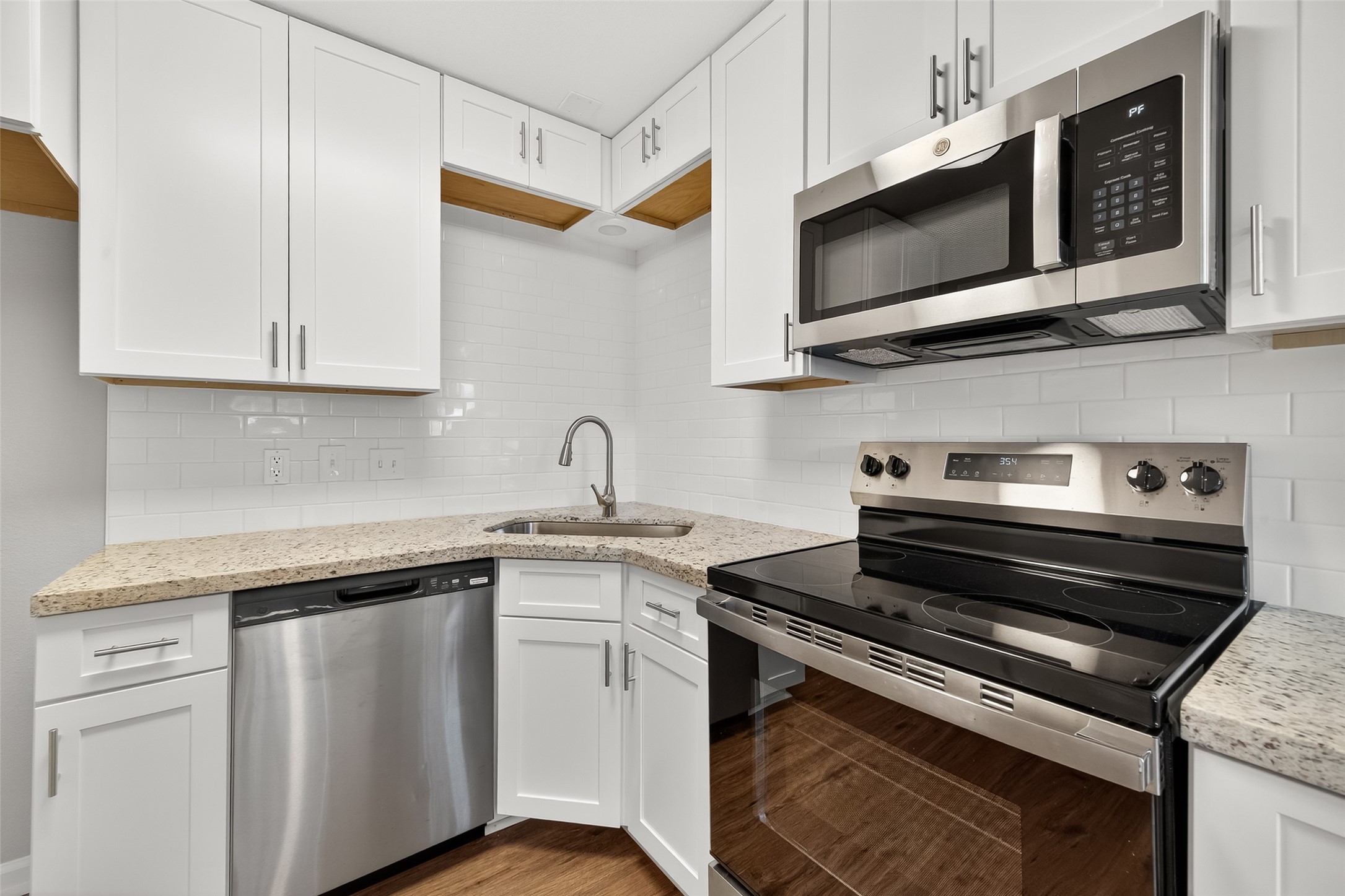 7047 Bissonnet Street, Unit 54 Houston, TX 77074 - Photo 16 of 30 a kitchen with stainless steel appliances granite countertop a sink and a microwave