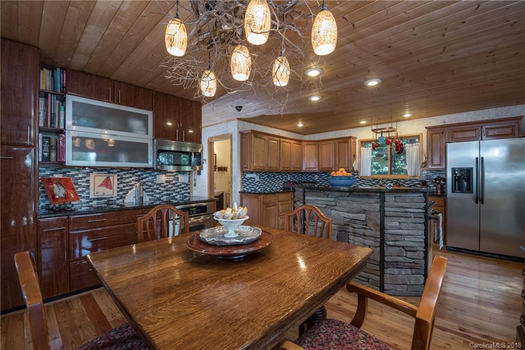 185 Caledonia Road Landrum, SC 29356 - Photo 15 of 30 a view of a dining room with furniture a chandelier and wooden floor