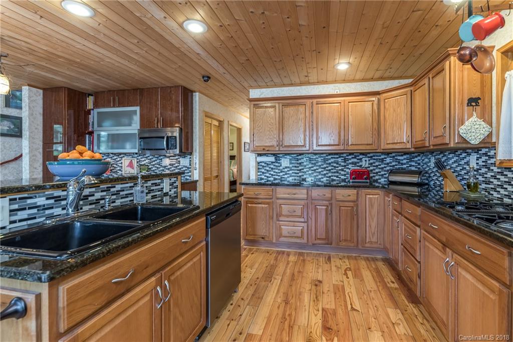 185 Caledonia Road Landrum, SC 29356 - Photo 16 of 30 a kitchen with granite countertop a sink stove and cabinets