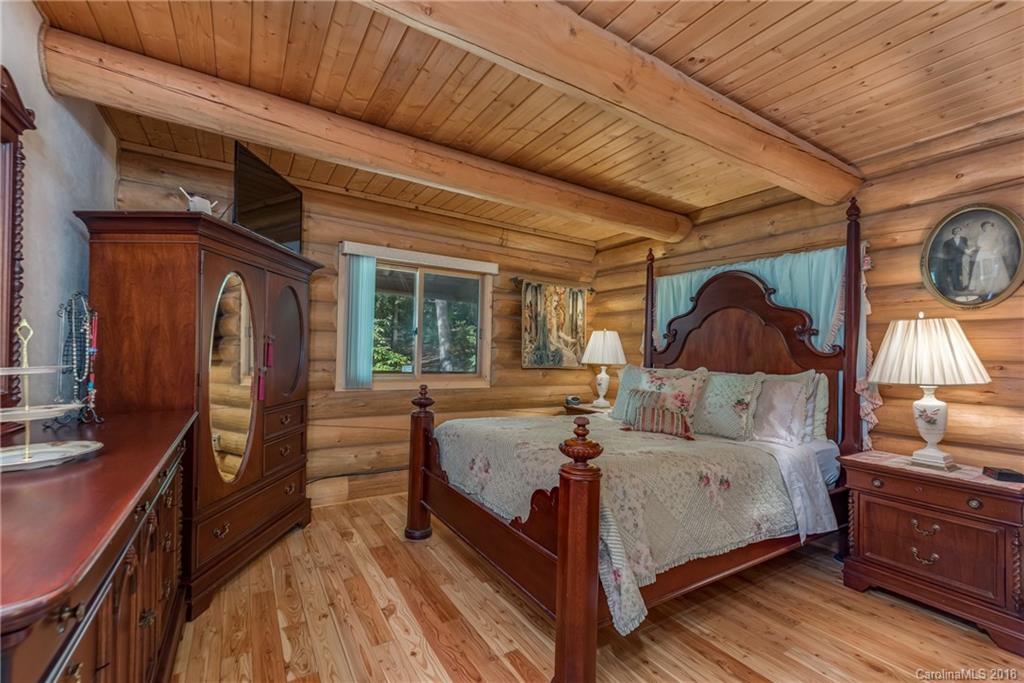 185 Caledonia Road Landrum, SC 29356 - Photo 21 of 30 a bedroom with a bed and a large window with wooden floor