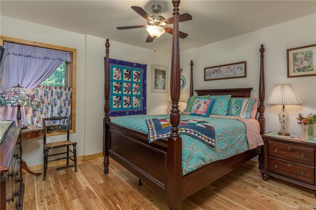 185 Caledonia Road Landrum, SC 29356 - Photo 24 of 30 a bedroom with a bed and a chandelier