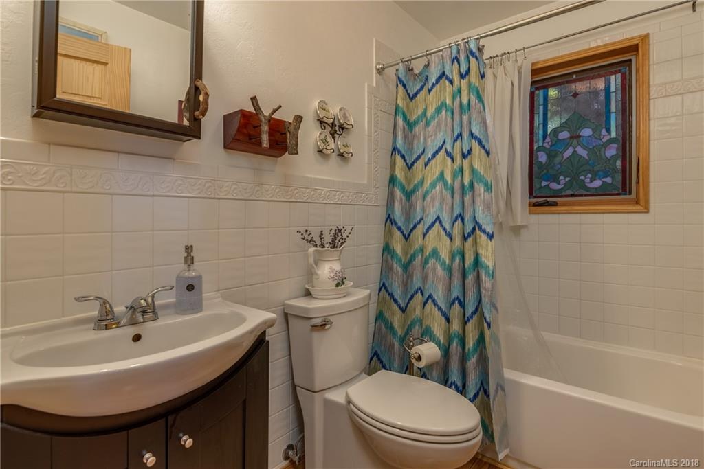 185 Caledonia Road Landrum, SC 29356 - Photo 25 of 30 a bathroom with a toilet a sink and mirror