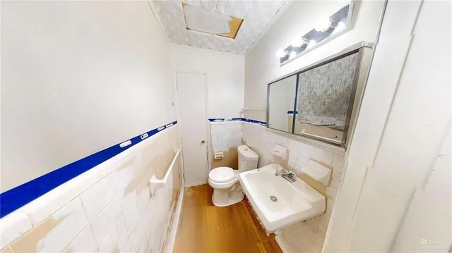 a bathroom with a toilet sink and mirror