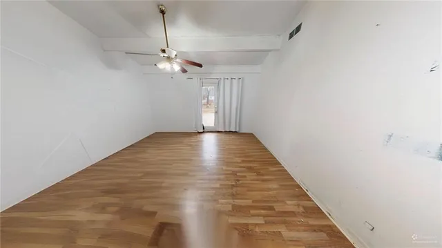 a view of empty room with wooden floor