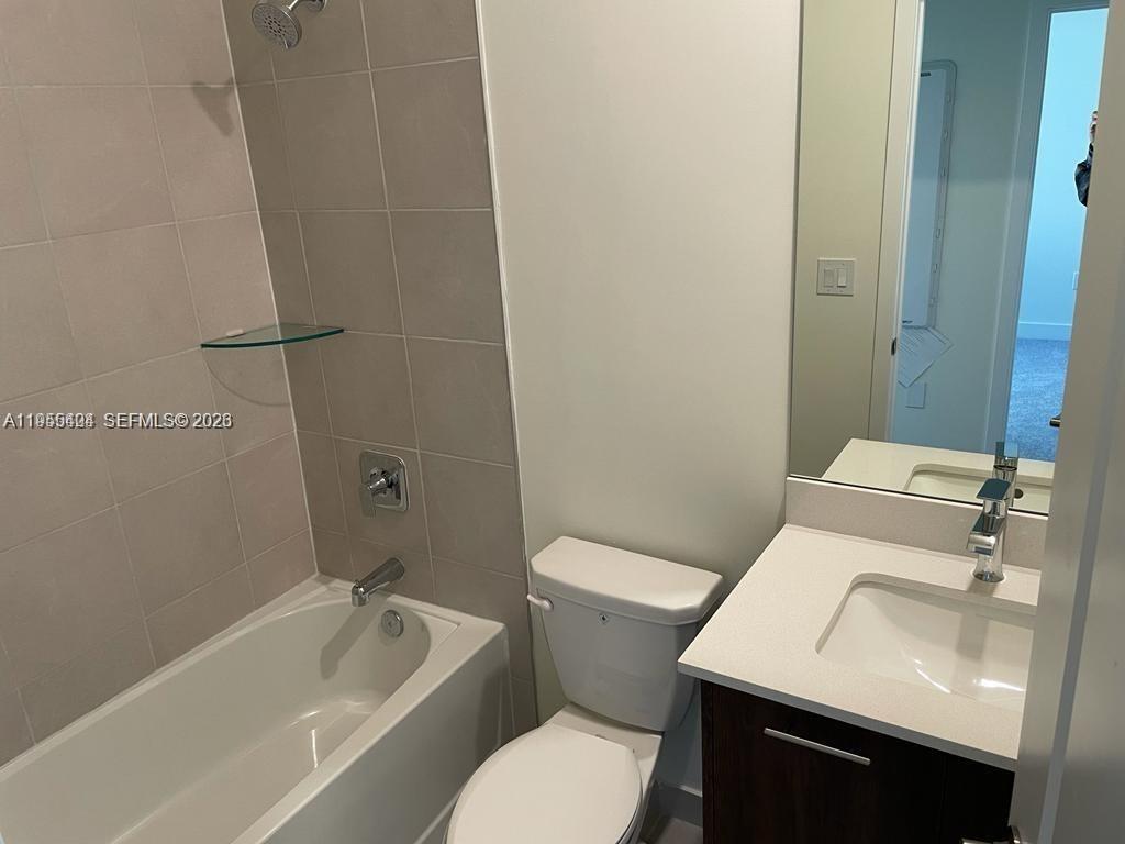 4657 Northwest 83rd Path Doral, FL 33166 - Photo 14 of 23 a white toilet sitting next to a bath tub