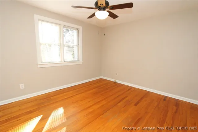 an empty room with a window and a ceiling fan