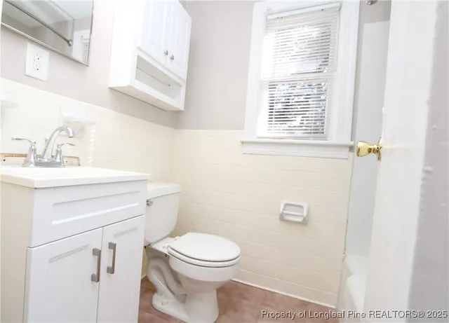 a bathroom with a sink a toilet and a window