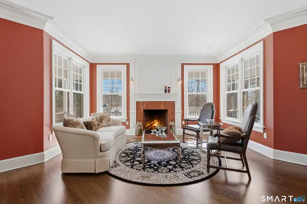 a living room with furniture a fireplace and large windows