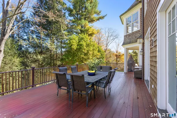 a view of a roof deck with table and chairs and wooden floor