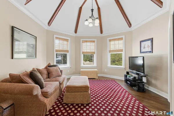 a living room with furniture a flat screen tv and a window