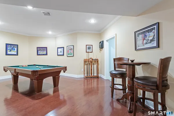 a room with furniture pool table and wooden floor