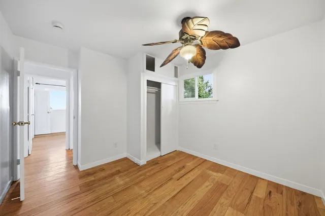 a view of empty room with wooden floor