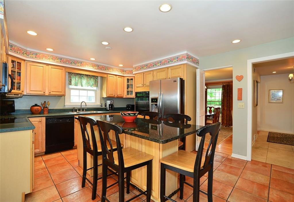 Updated kitchen features a granite island and stainless appliances.