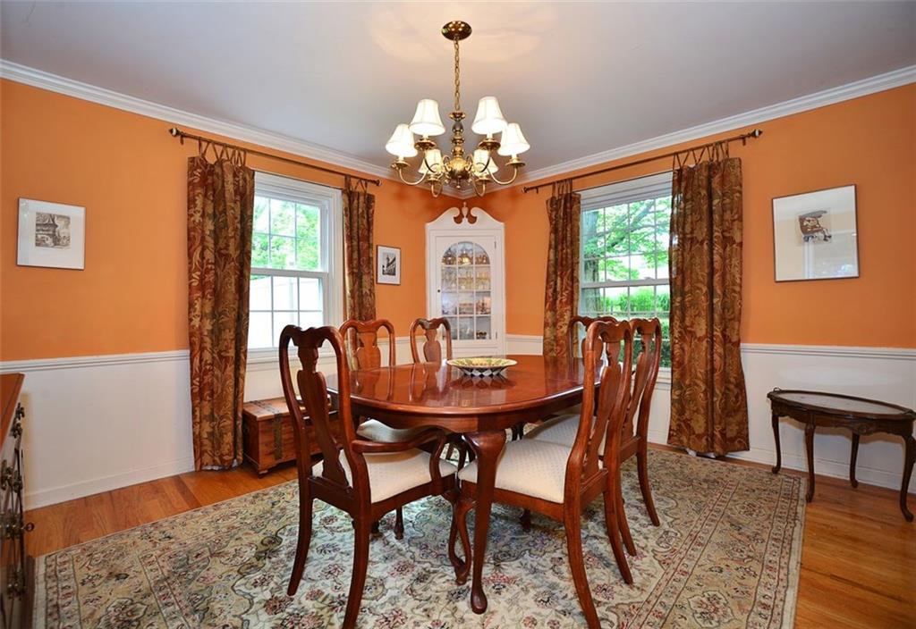 Spacious Dining room with crown molding and chair rail along with a built in corner china cupboard and hardwood floors. 