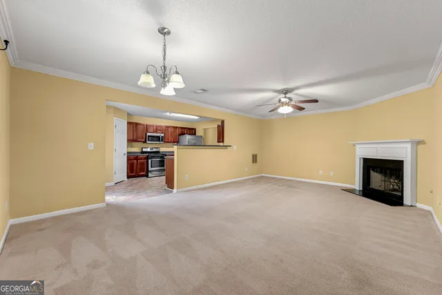 an empty room with kitchen and fireplace