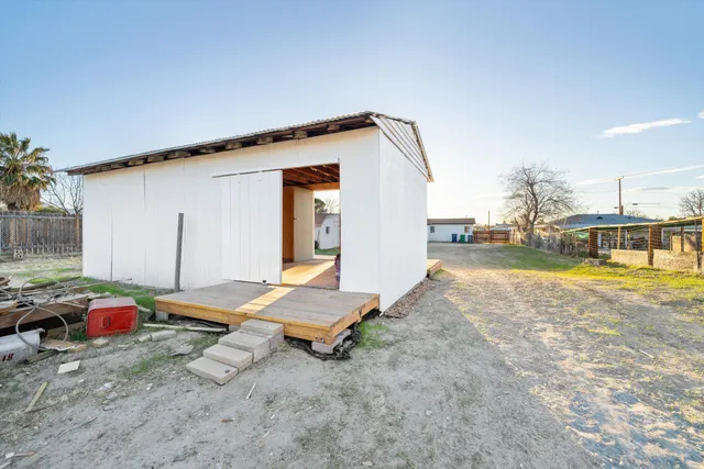a backyard of a house with barbeque oven table and chairs