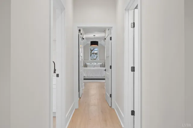 a view of a hallway with wooden floor and closet