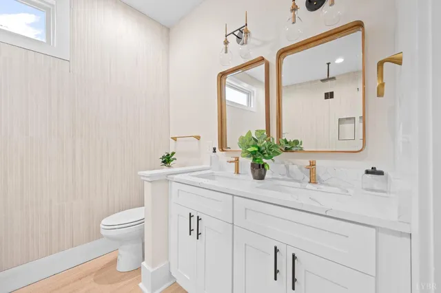 a bathroom with a granite countertop sink a toilet and a mirror
