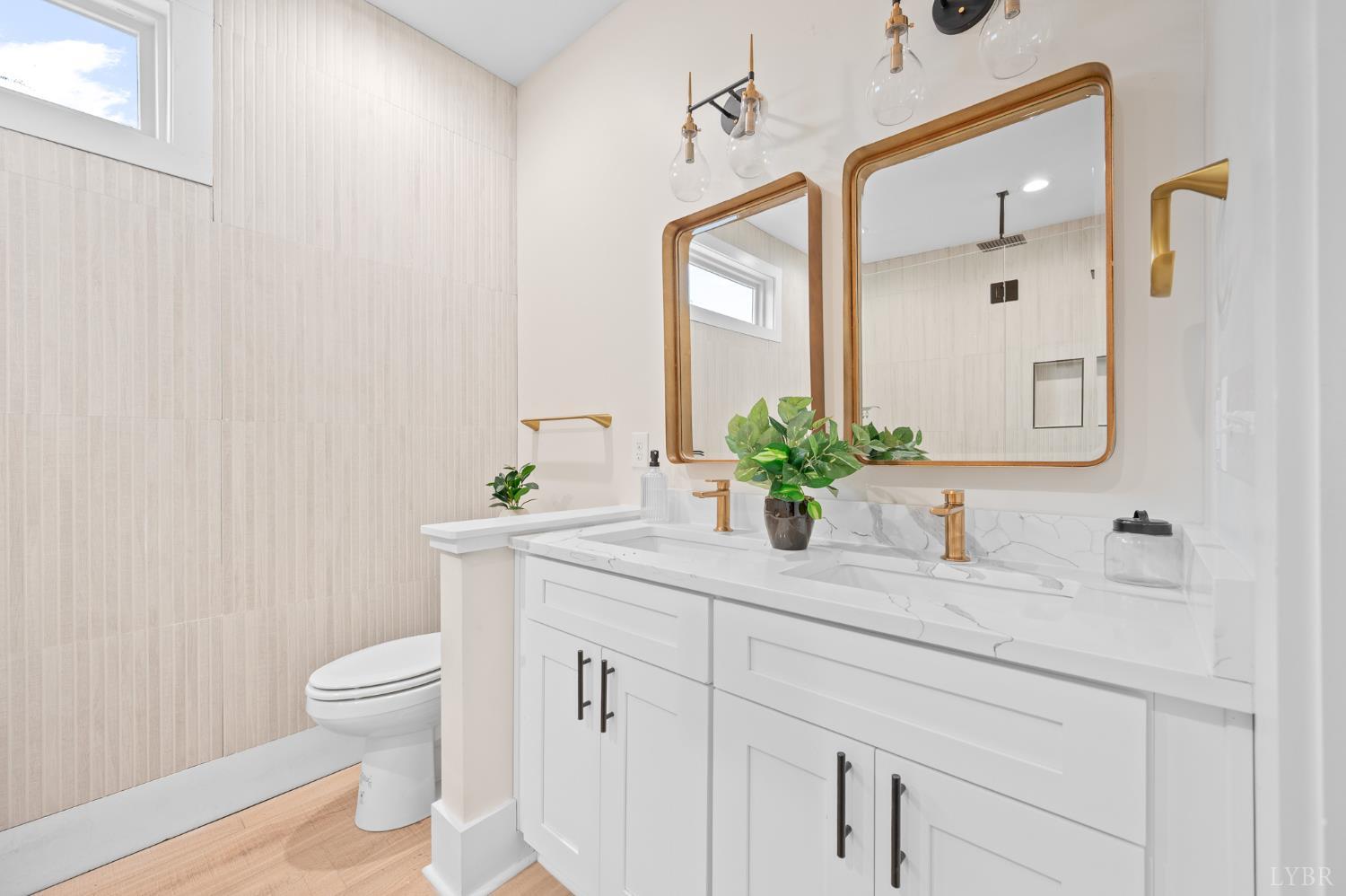 3741 Lowry Road Goode, VA 24556 - Photo 18 of 54 a bathroom with a granite countertop sink a toilet and a mirror