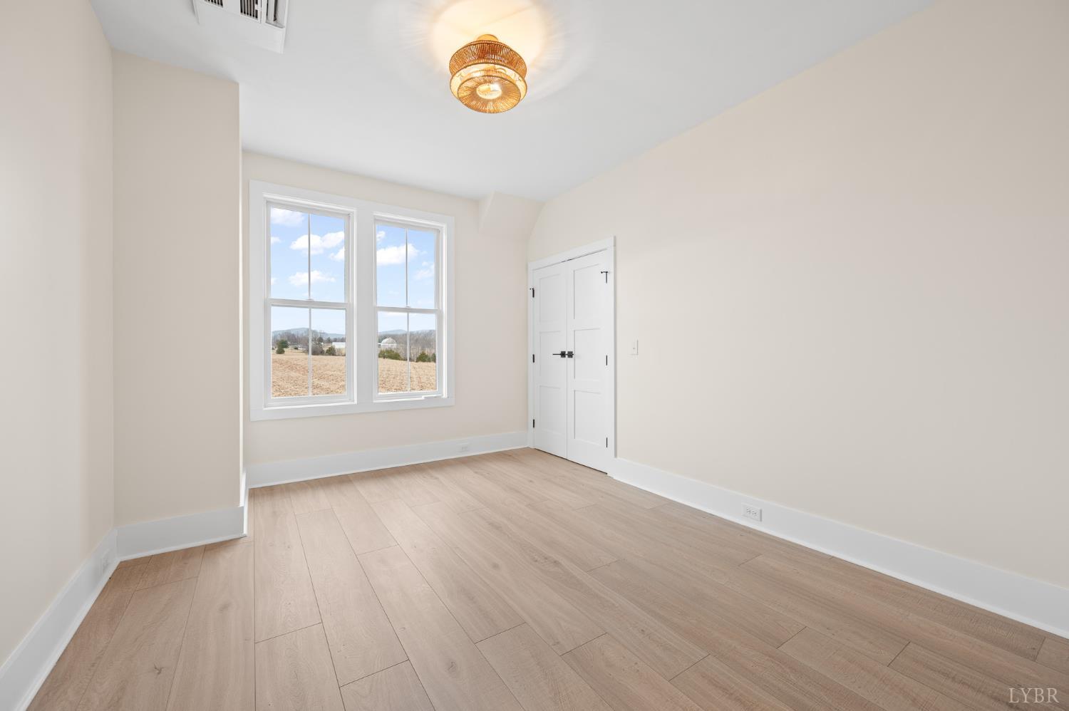 3741 Lowry Road Goode, VA 24556 - Photo 25 of 54 an empty room with wooden floor and windows
