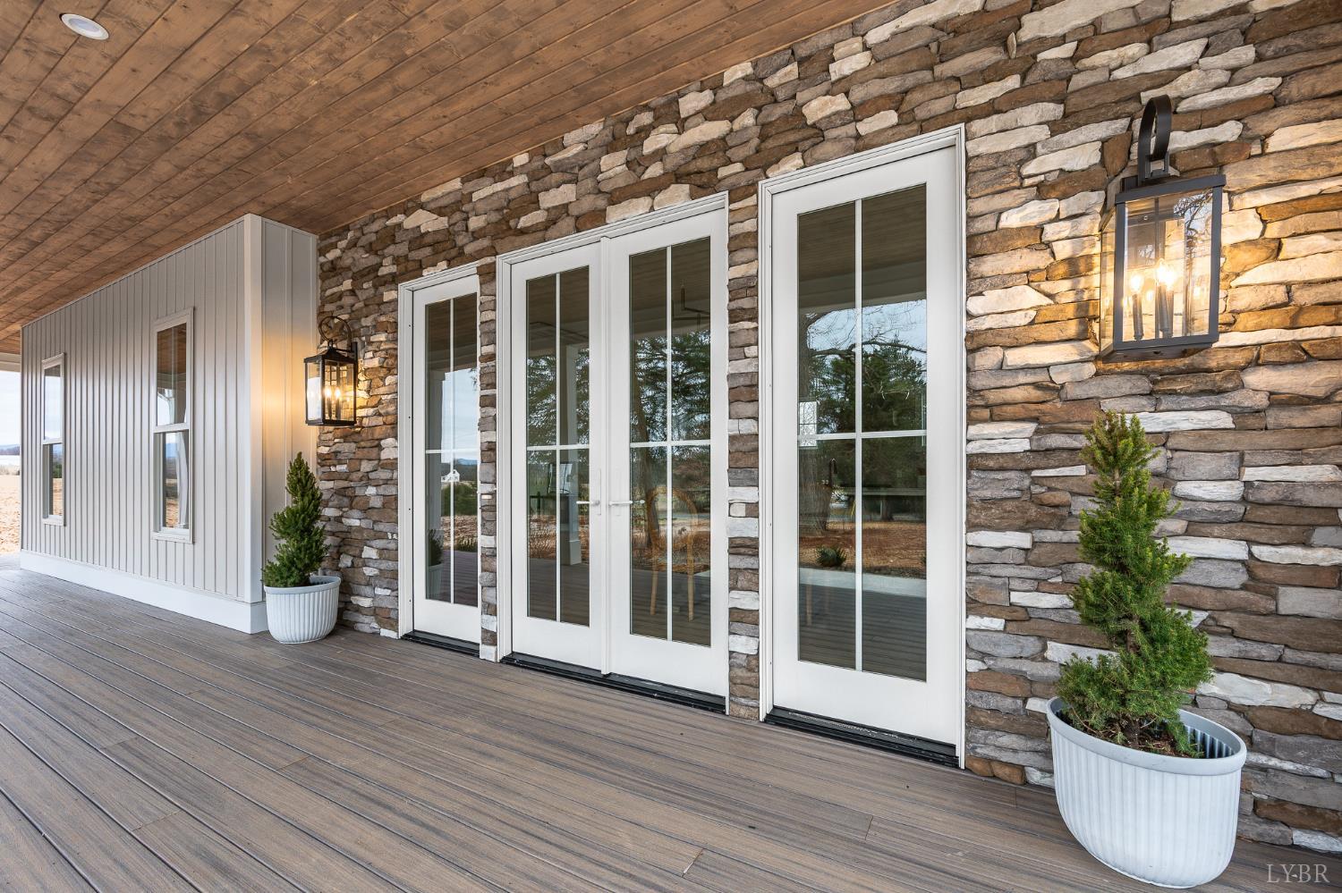 3741 Lowry Road Goode, VA 24556 - Photo 34 of 54 a view of a house with a potted plant and floor to ceiling windows