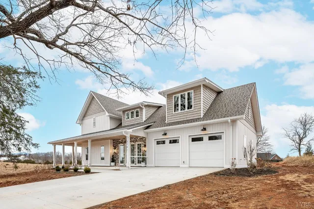 a view of a white house with a large tree