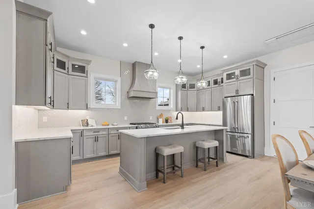 a kitchen with kitchen island a dining table chairs sink and cabinets