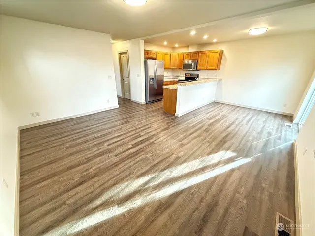 a view of kitchen with stainless steel appliances wooden floor
