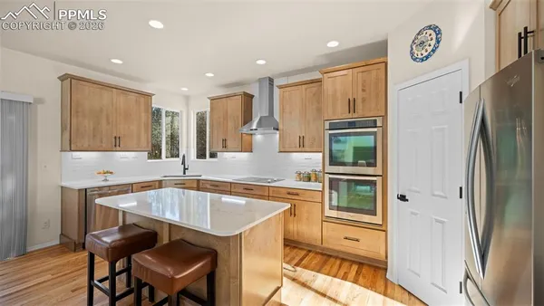 a kitchen with stainless steel appliances granite countertop a refrigerator and a sink