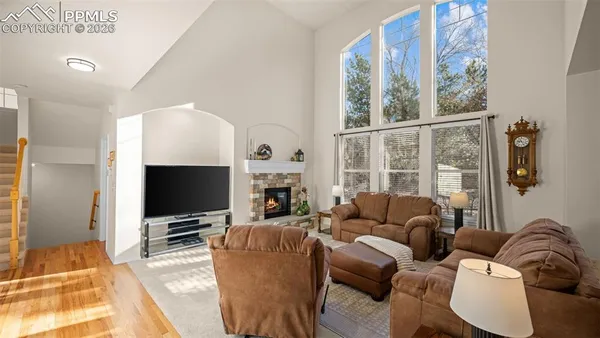 a living room with furniture a flat screen tv and a large window