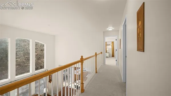 a view of a hallway with wooden floor and entryway