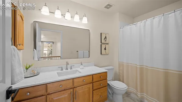 a bathroom with a granite countertop sink a toilet and a mirror