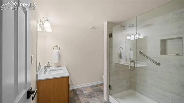 a bathroom with a shower a mirror and a sink