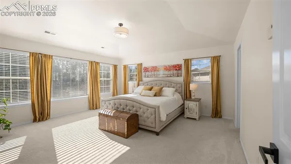 a bedroom with a bed wooden floor and window