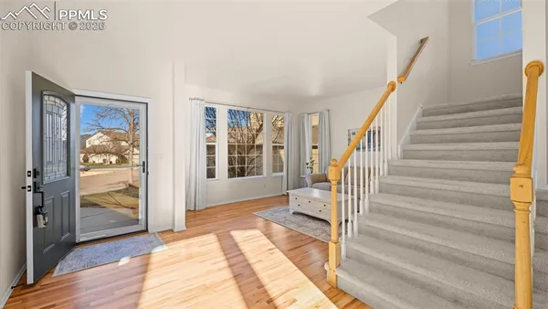 a view of a livingroom with wooden floor and stairs