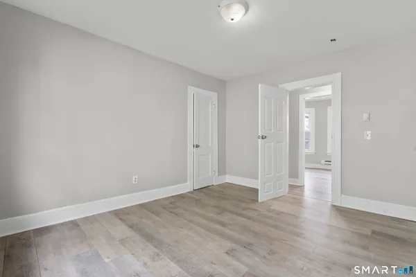 a view of an empty room with wooden floor