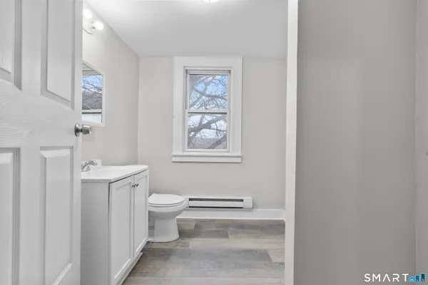 a bathroom with a toilet a sink and a window