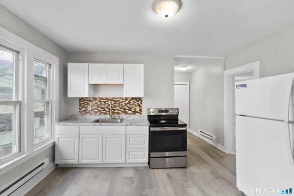 a kitchen with a refrigerator and a stove top oven