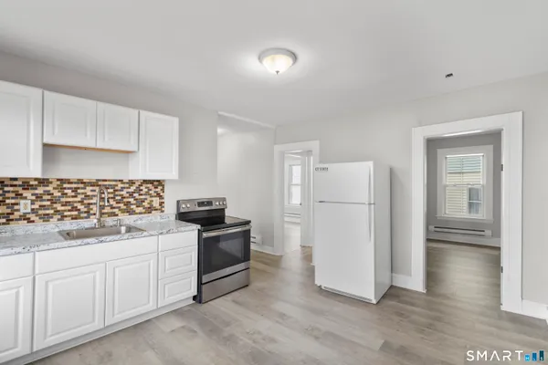 a kitchen with white cabinets and white appliances