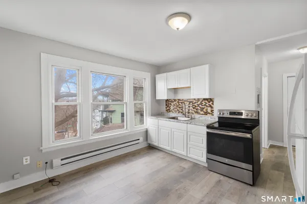 a kitchen with granite countertop a stove and a refrigerator